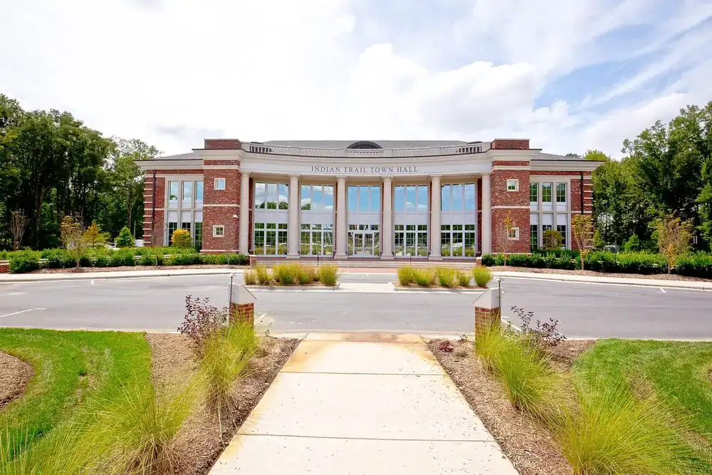 The columned brick Indian Trail Town Hall behind a landscaped walkway in North Carolina